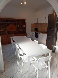 a kitchen with a white table and white chairs at Bükfalva Bercsényi13 in Bük