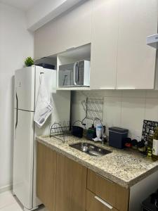 a kitchen with a white refrigerator and a sink at Studio Home Office Completo Cama Queen e Ar Condicionado Vista Panorâmica in Mogi das Cruzes +70 photos