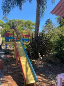 a playground with a slide in front of a palm tree at Sítio Vitória in Barracão