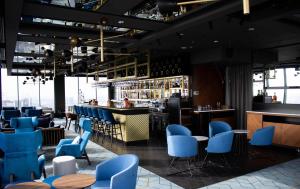 カトヴィツェにあるCourtyard by Marriott Katowice City Centerの青い椅子とバーのあるレストラン
