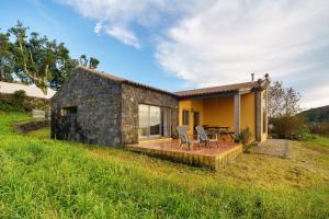 a small stone house with a deck and patio at Serreta Island Home in Serreta