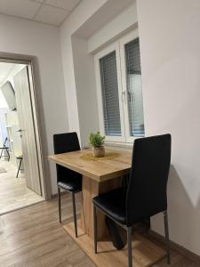 a dining room table with two black chairs and a table at Apartma Center Ljutomer in Ljutomer +2 photos