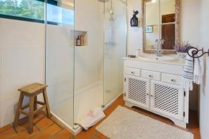 a bathroom with a shower and a sink and a stool at Serreta Island Home in Serreta +49 photos