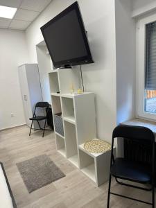 a flat screen tv on top of a white book shelf at Apartma Center Ljutomer in Ljutomer