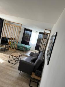 a living room with a couch and a room with windows at Beachfront Studio in Marigot