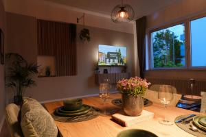 a dining room table with glasses and flowers on it at Apartment am Tannenwäldchen im Vorderer Westen Kassel by CASTORA HOMES in Kassel