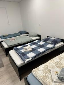 a group of three beds in a room at Apartma Center Ljutomer in Ljutomer