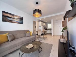 a living room with a couch and a table at Poseidon 6 - cozy apartment with swimming pool in Puerto de Santiago +2 photos