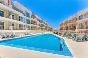 a swimming pool in front of a apartment building at Poseidon 6 - cozy apartment with swimming pool in Puerto de Santiago
