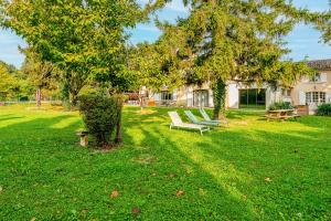 a park with two benches sitting under a tree at Chambre D'hôtes Nature in Cabannes