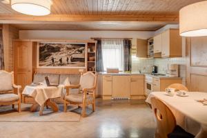 Una cocina y un comedor con mesas y sillas. en Alpengasthof Pichler, en Sankt Veit in Defereggen