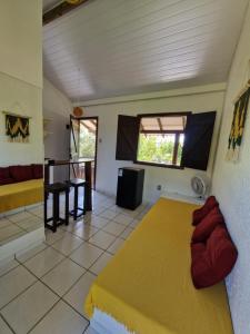 a bedroom with a large yellow bed in a room at Pousada Aconchego do Rosa - Centrinho do Rosa in Praia do Rosa +9 photos