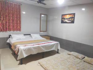 a bedroom with two beds and a window and a rug at Sai Samata Lodging Boarding in Junnar