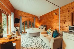a living room with a bed in a wooden wall at Robin Woodside Lodge in Caerwys