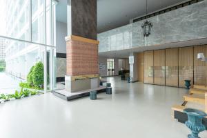 un hall d'un immeuble avec bancs et fenêtres dans l'établissement Boathouse Hua Hin Condo, à Ban Bo Fai (1)