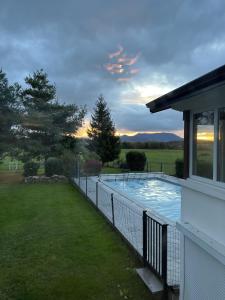 una casa con una recinzione intorno alla piscina di Villa 170m2 avec piscine , terrain de petanque, billard et jeux de flechettes a Nompatelize