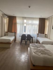 ein Hotelzimmer mit zwei Betten und einem Tisch in der Unterkunft Alice İn Taksim Apart in Istanbul