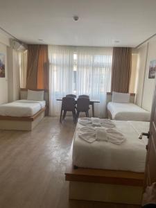 ein Hotelzimmer mit zwei Betten und einem Tisch in der Unterkunft Alice İn Taksim Apart in Istanbul