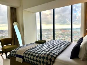 a bedroom with a bed and a large window at Flysleep Apartemen Pollux Habibie Batam 1BR Sea View n City in Batam Center +17 photos