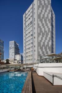 a building with a swimming pool in front of a building at Metropolitan Hotel in Tel Aviv