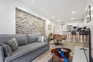 a living room with a couch and a stone wall at Tanoeiros Residence by An Island Apart in Funchal