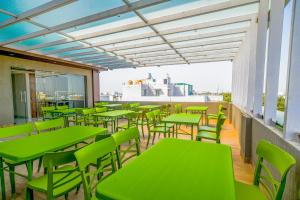 a row of green tables and chairs on a balcony at The Byke Express - Near Gopur Square in Indore