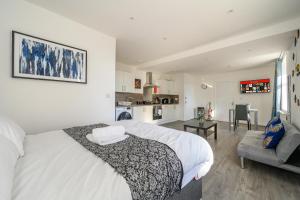 ブラッドフォードにある11F1 Captivating & luxurious Stayの大きな白いベッドとキッチンのある寝室