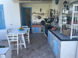 een keuken met een aanrecht, een tafel en stoelen bij La Villa di Nina in Favignana