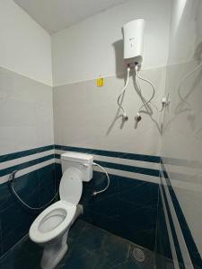 a bathroom with a white toilet in a room at Sateri Homestay Gokarna Beach in Gokarn