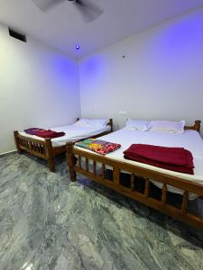 two beds sitting next to each other in a room at Sateri Homestay Gokarna Beach in Gokarn