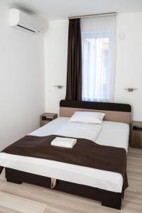 a bedroom with a large bed and a window at M&F Apartman in Egerszalók