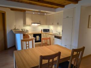 a kitchen with a wooden table and chairs in it at Sundance 5 in Les Crosets