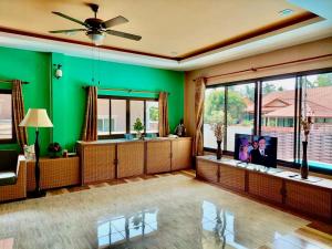a living room with green walls and a flat screen tv at Leelawadee House - 3 bedroom private villa with pool in Nathon Bay