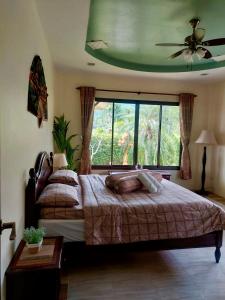 a bedroom with a bed and a large window at Leelawadee House - 3 bedroom private villa with pool in Nathon Bay +9 photos