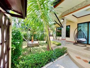 a palm tree in the courtyard of a house at Leelawadee House - 3 bedroom private villa with pool in Nathon Bay