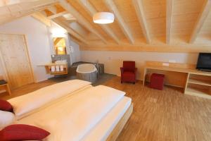 a bedroom with a large bed in a room with wooden ceilings at Hotel Espen in Engelberg