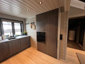 una cocina con fregadero y estufa en Large Balcony With Panoramic Mountain Views, en Beitostølen