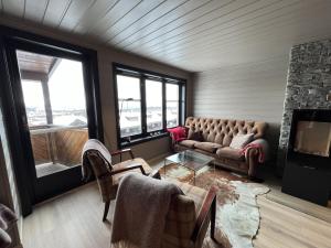 Una sala de estar con un sofá y una chimenea. en Large Balcony With Panoramic Mountain Views, en Beitostølen