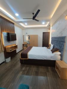 a hotel room with a bed and a flat screen tv at Green Palace Inn, T Nagar in Chennai