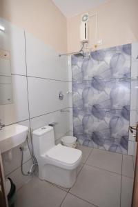 ein weißes Badezimmer mit Dusche und Toilette in der Unterkunft NALINAM HOMESTAY in Thiruvananthapuram + 77 Fotos