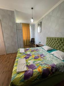 une chambre avec un grand lit avec une couverture colorée dans l'établissement Happy Rustavi guest house, à Roustavi 36 autres photos
