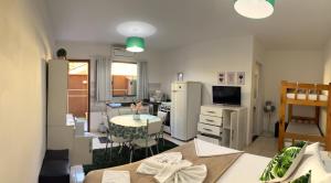 a kitchen with a table and a kitchen with a refrigerator at Pousada Anjos - à 2 quadras do mar in Matinhos