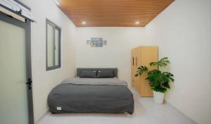a bedroom with a bed and a potted plant at Amy Hotel & Apartment in Da Thanh