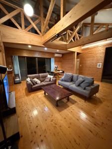 高森町にある閼宗屋 Asoyaのソファとコーヒーテーブル付きの広いリビングルーム