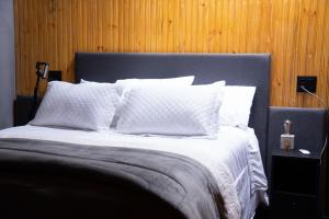 a bedroom with a large bed with white sheets and pillows at Luxury Cabin at 1,600m altitude in São Bento do Sapucaí
