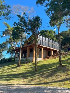 a house on top of a hill with trees at Luxury Cabin at 1,600m altitude in São Bento do Sapucaí