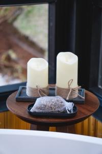 two candles sitting on a table with a plate at Luxury Cabin at 1,600m altitude in São Bento do Sapucaí +34 photos
