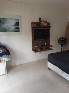 a bedroom with a bed and a tv on a wall at Recanto praiano in Torres
