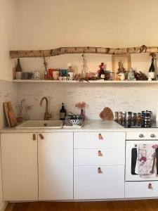 a kitchen with white cabinets and a sink at Bloom as you are in Bologna +26 photos