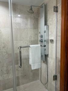 a shower with a glass door with a towel at The Eldon Luxury Suites in Washington +24 photos